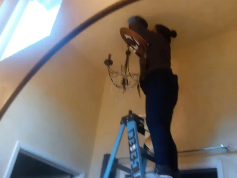 Electrician installing a chandelier in a Carson residence